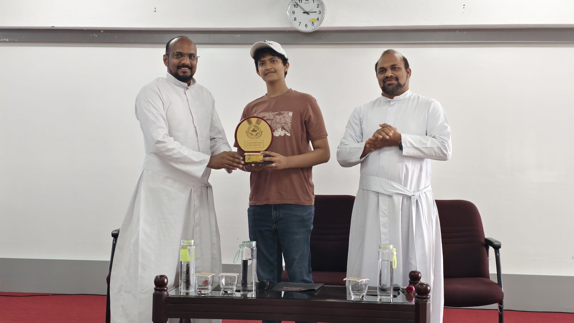 A WIEMO student facilitator receiving a commemorative plaque